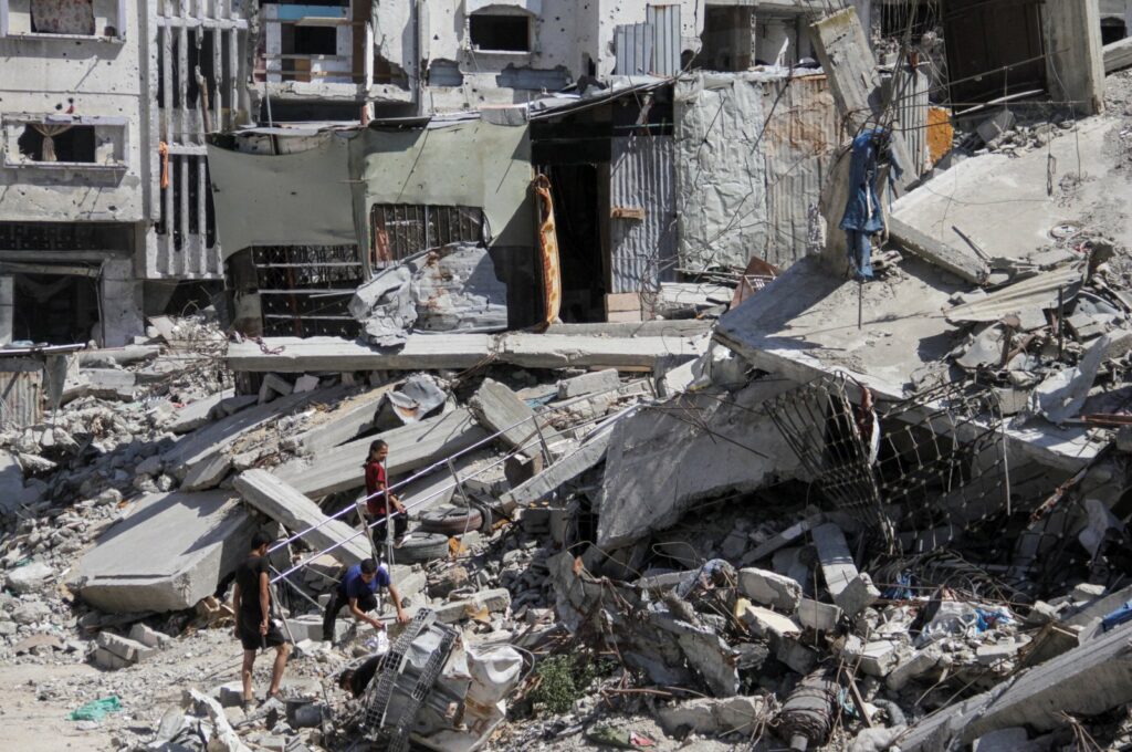 Palestinians walk among the rubble of damaged buildings, which were destroyed during Israel's attacks, Gaza, Palestine, June 12, 2024. (Reuters Photo)