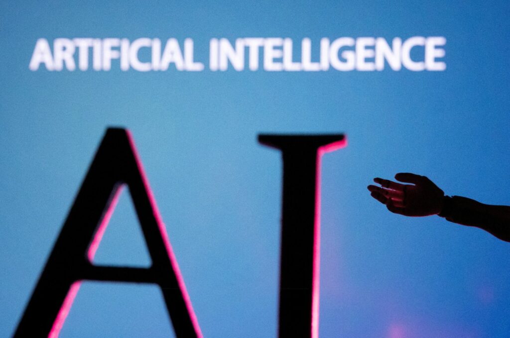 Artificial Intelligence letters and robot hand miniature are seen in this illustration taken on June 23, 2023. (Reuters Photo)