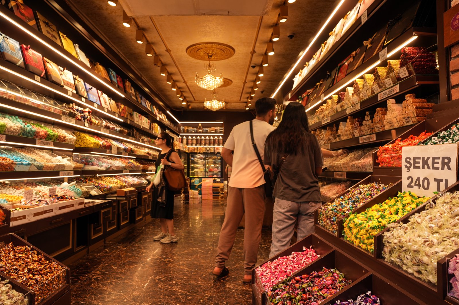 Customers shop for candies at a store in the famous Eminönü neighborhood in Istanbul, Türkiye, June 13, 2024. (IHA Photo)