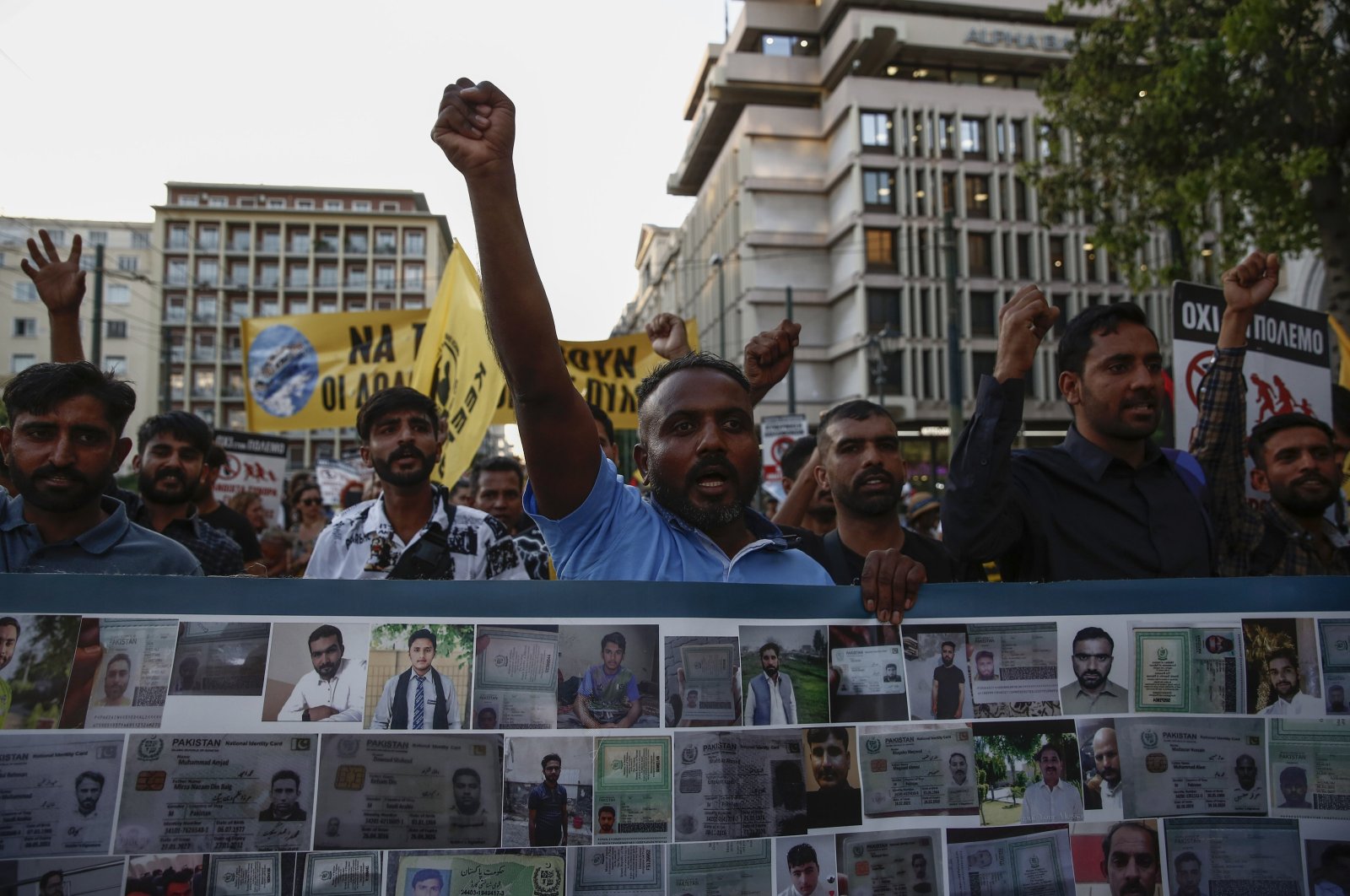 Protesters and survivors shout slogans as they hold a banner with pictures of missing and dead migrants during a rally in remembrance of the Pylos shipwreck one year ago, central Athens, Greece, June 14, 2024. (EPA Photo)