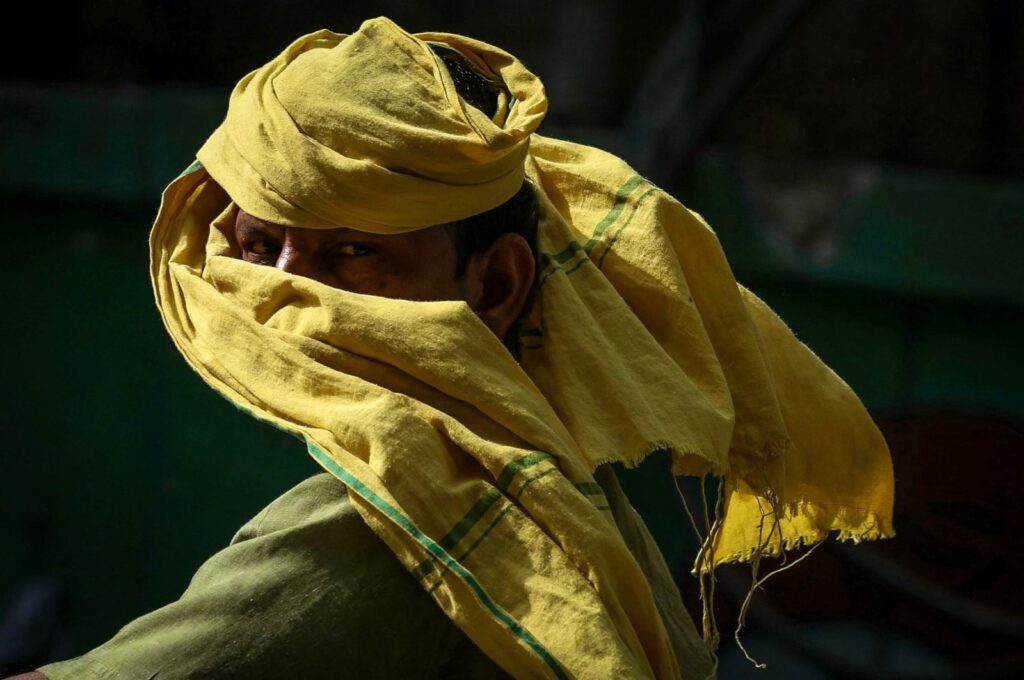 A man riding a two-wheeler looks on as he covers his face with a cloth on a hot summer day amid a severe heatwave in Varanasi, India, May 30, 2024. (AFP Photo)