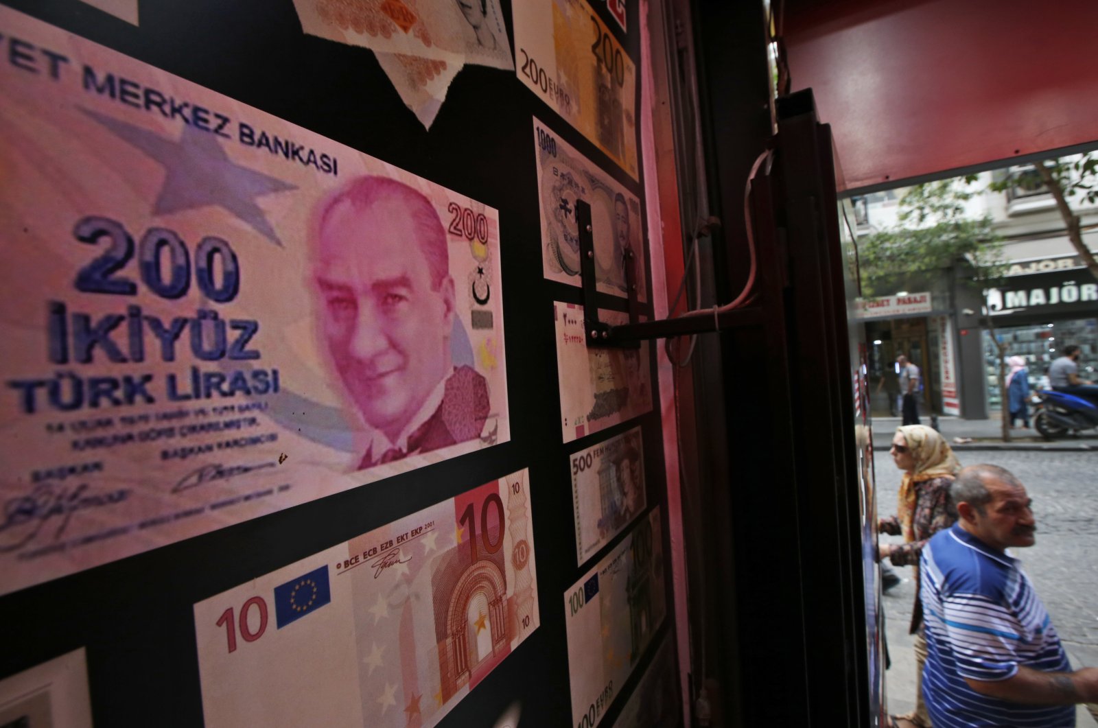 An oversized copy of a TL 200 banknote featuring a photo of modern Türkiye's founder Mustafa Kemal Atatürk decorates a currency exchange shop, Istanbul, Türkiye, Aug. 17, 2018. (AP Photo)