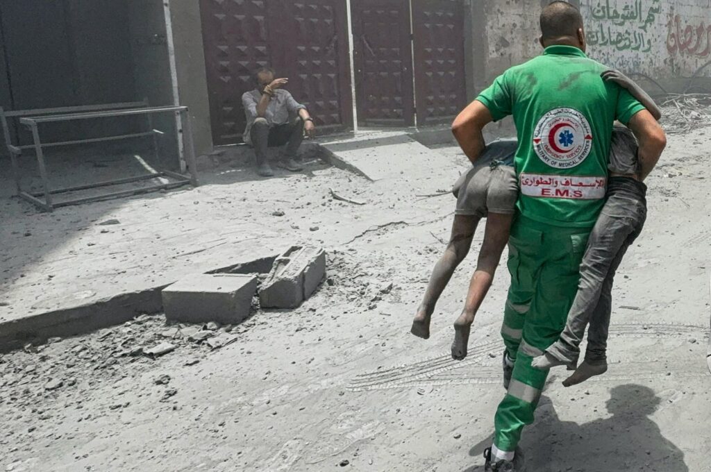 A Palestinian rescue worker carries casualties at the site of Israeli strikes on houses at al-Shati refugee camp in Gaza City, Palestine, June 22, 2024. (Reuters Photo)