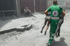 A Palestinian rescue worker carries casualties at the site of Israeli strikes on houses at al-Shati refugee camp in Gaza City, Palestine, June 22, 2024. (Reuters Photo)