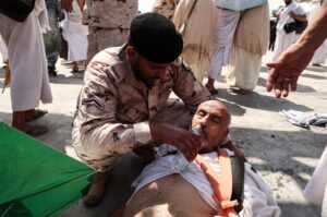 A man affected by the scorching heat is helped by a member of the Saudi security forces in Mina, near the holy city of Mecca, Saudi Arabia, June 16, 2024. (AFP Photo)