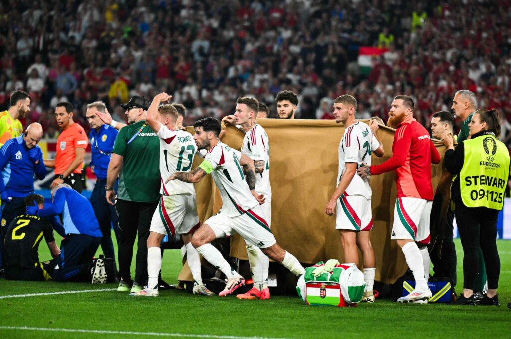 Players and stewards hold a cloth as Hungary's forward Barnabas Varga receives medical treatment after a collision during the UEFA Euro 2024 Group A football match between Scotland and Hungary, Stuttgart Arena, Stuttgart, Germany, June 23, 2024. (AFP Photo)