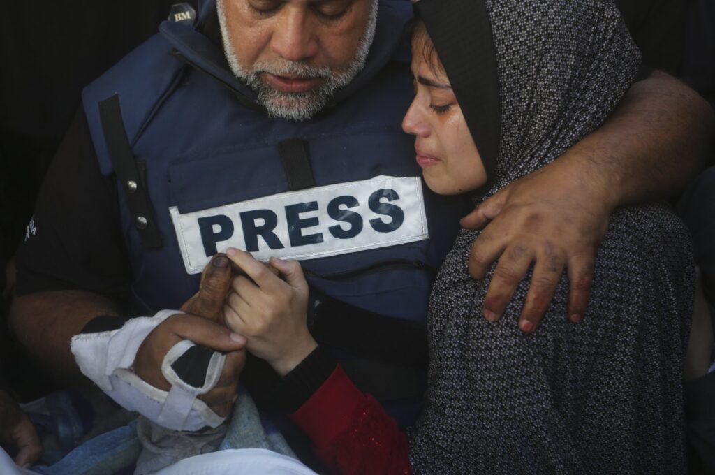 Al Jazeera journalist Wael al-Dahdouh holds the hand of his son Hamza, who also worked for Al Jazeera and was killed in an Israeli airstrike in Rafah, Gaza Strip, Jan. 7, 2024. (AP Photo)