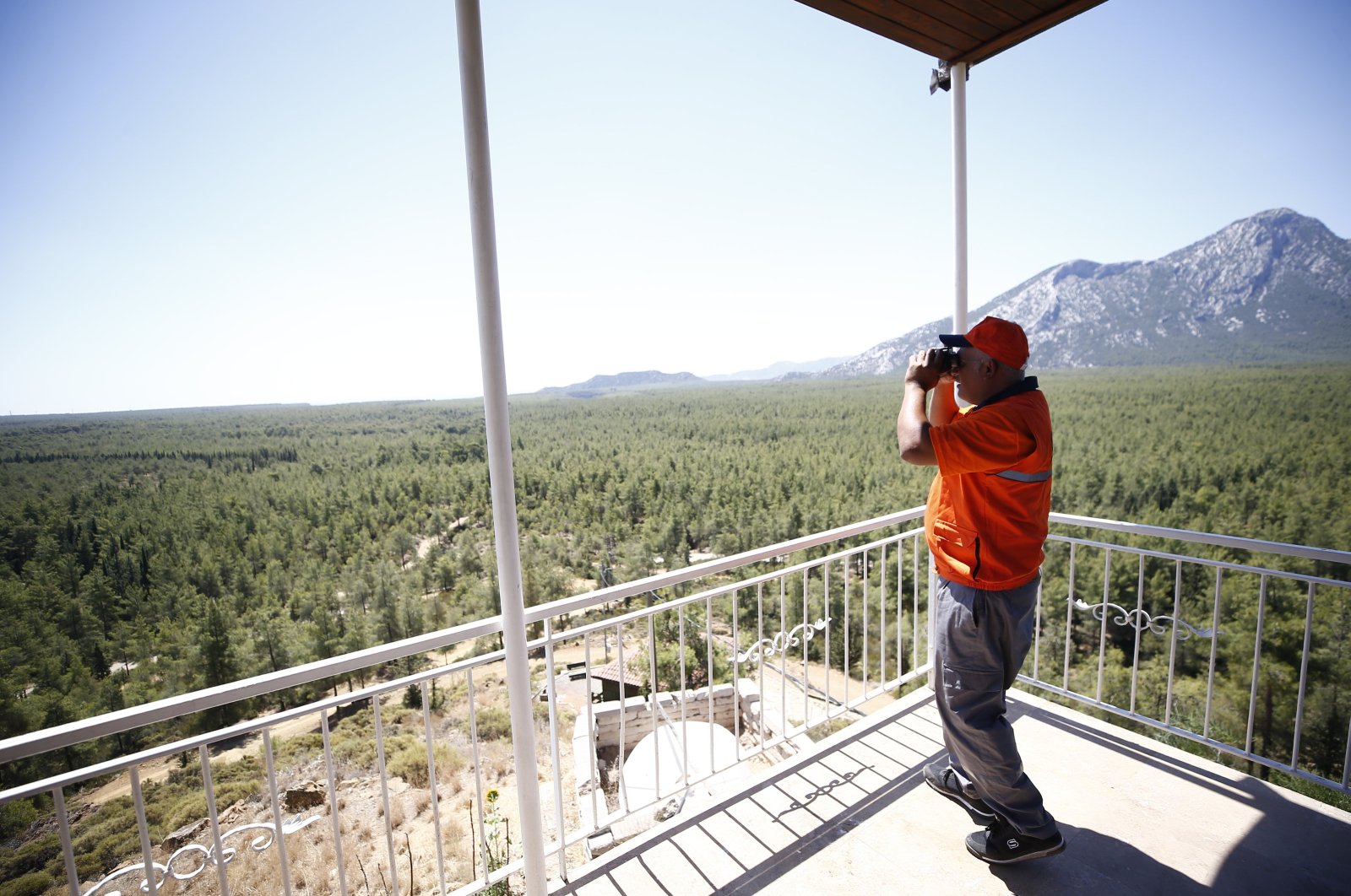 A personnel uses a binocular to watch over the forests in an observation tower, Antalya, western Türkiye, July 3, 2024. (AA Photo)