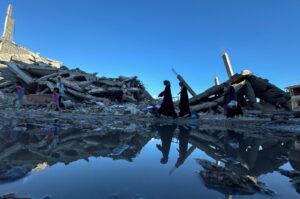 Palestinians walk past the rubble of houses destroyed in Israeli strikes, in Khan Younis in the southern Gaza Strip July 7, 2024. (Reuters Photo)