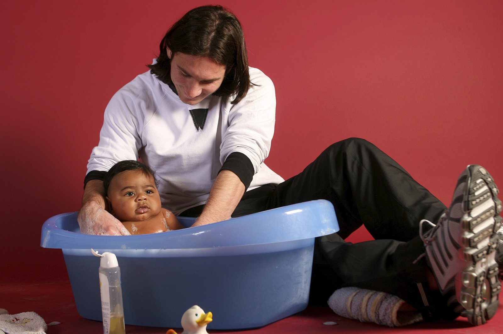 20-year-old Lionel Messi helping to bathe 6-month-old Lamine Yamal during a photo session in the dressing room of the Camp Nou stadium, Barcelona, Spain, Oct. 31, 2007. (AP Photo)