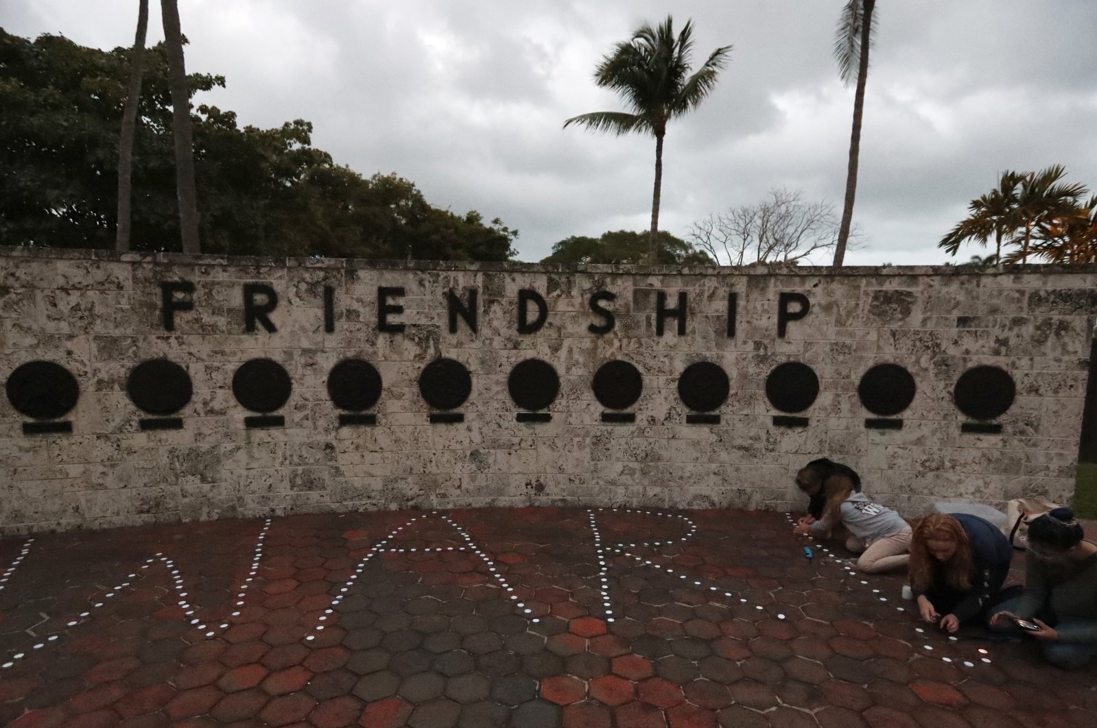 Anti-war demonstrators line up candles to spell "No War!," at the Torch of Friendship monument, in Miami, U.S., Jan. 9, 2020. (AP Photo)