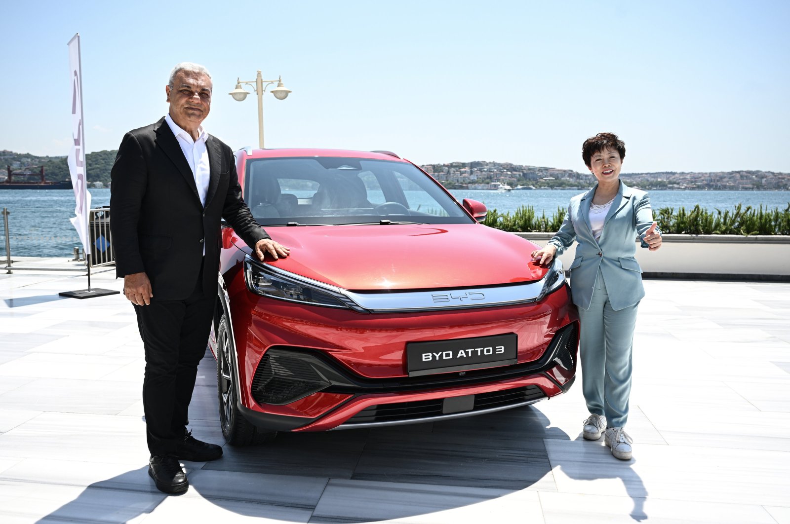 ALJ CEO Ali Haydar Bozkurt and CEO of BYD Americas Stella Li pose for a photo in front of a BYD vehicle in Istanbul, July 11, 2024. (AA Photo)