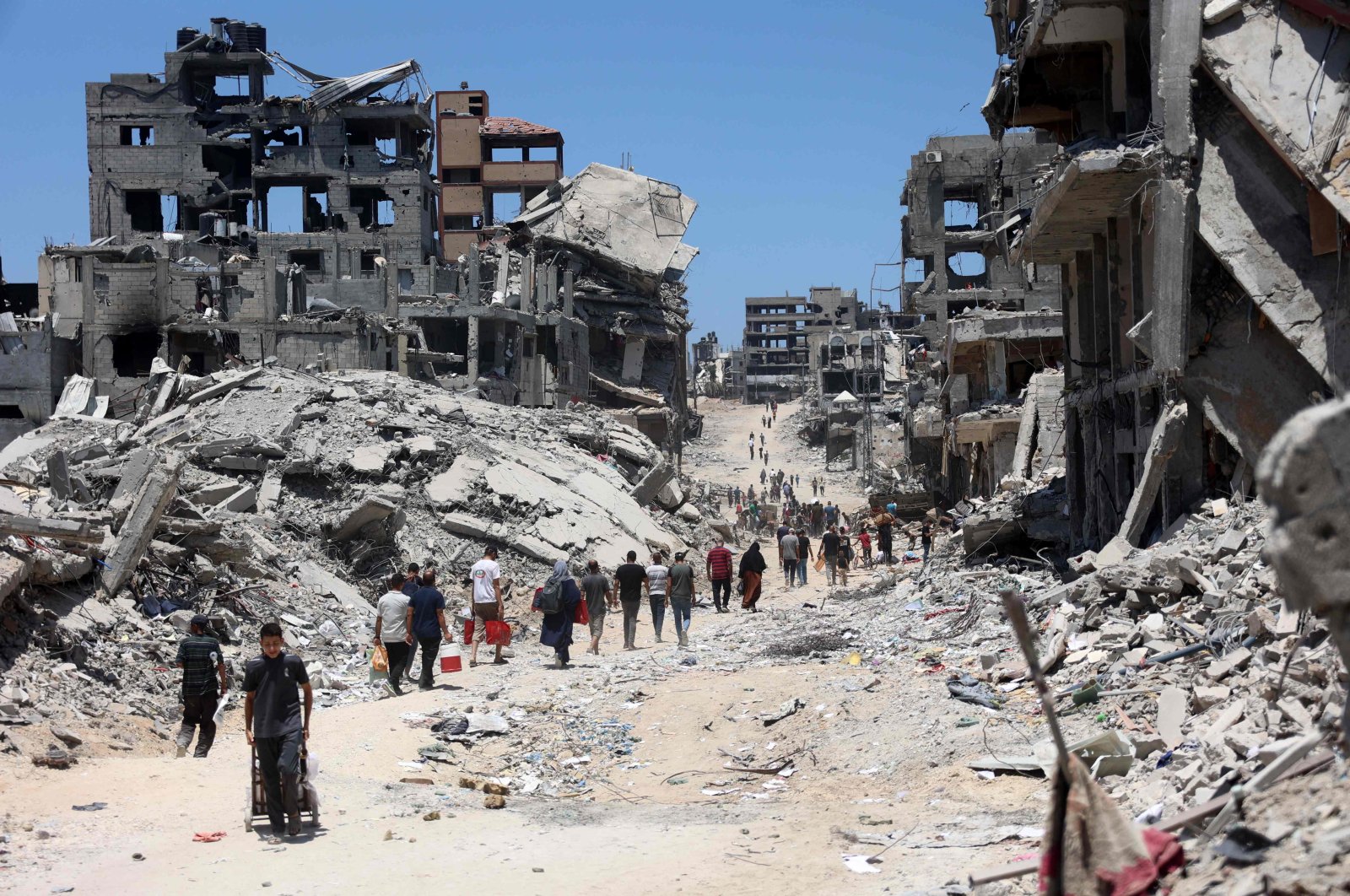 Palestinians walk through the rubble of destroyed buildings after the Israeli military withdrew following a two-week assault on the Shujaiya neighborhood, east of Gaza City, Palestine, July 11, 2024. (AFP Photo)