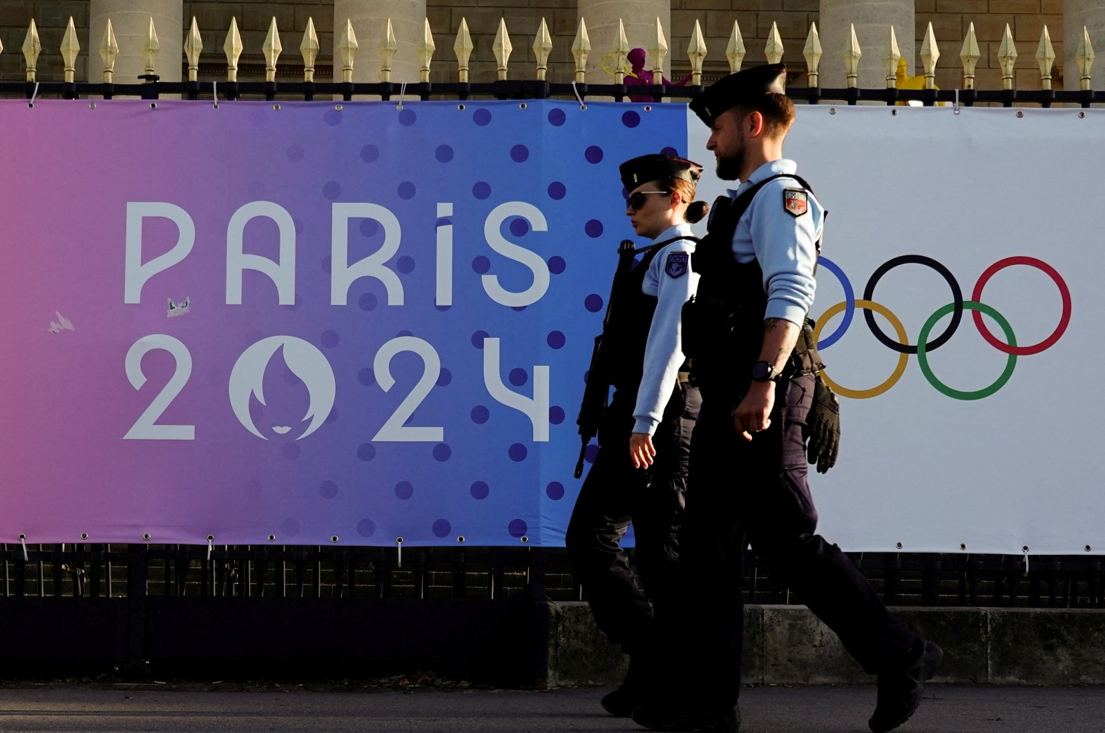 French police patrol a street near a poster advertising the Paris 2024 Summer Games, Paris, France, June 28, 2024. (Reuters Photo)