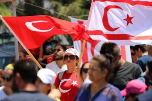 People wave Turkish Cypriot (R) and Turkish flags during a military parade on the anniversary of Türkiye's Peace Operation, Lefkoşa (Nicosia), Turkish Republic of Northern Cyprus, July 20, 2024. (AFP Photo)