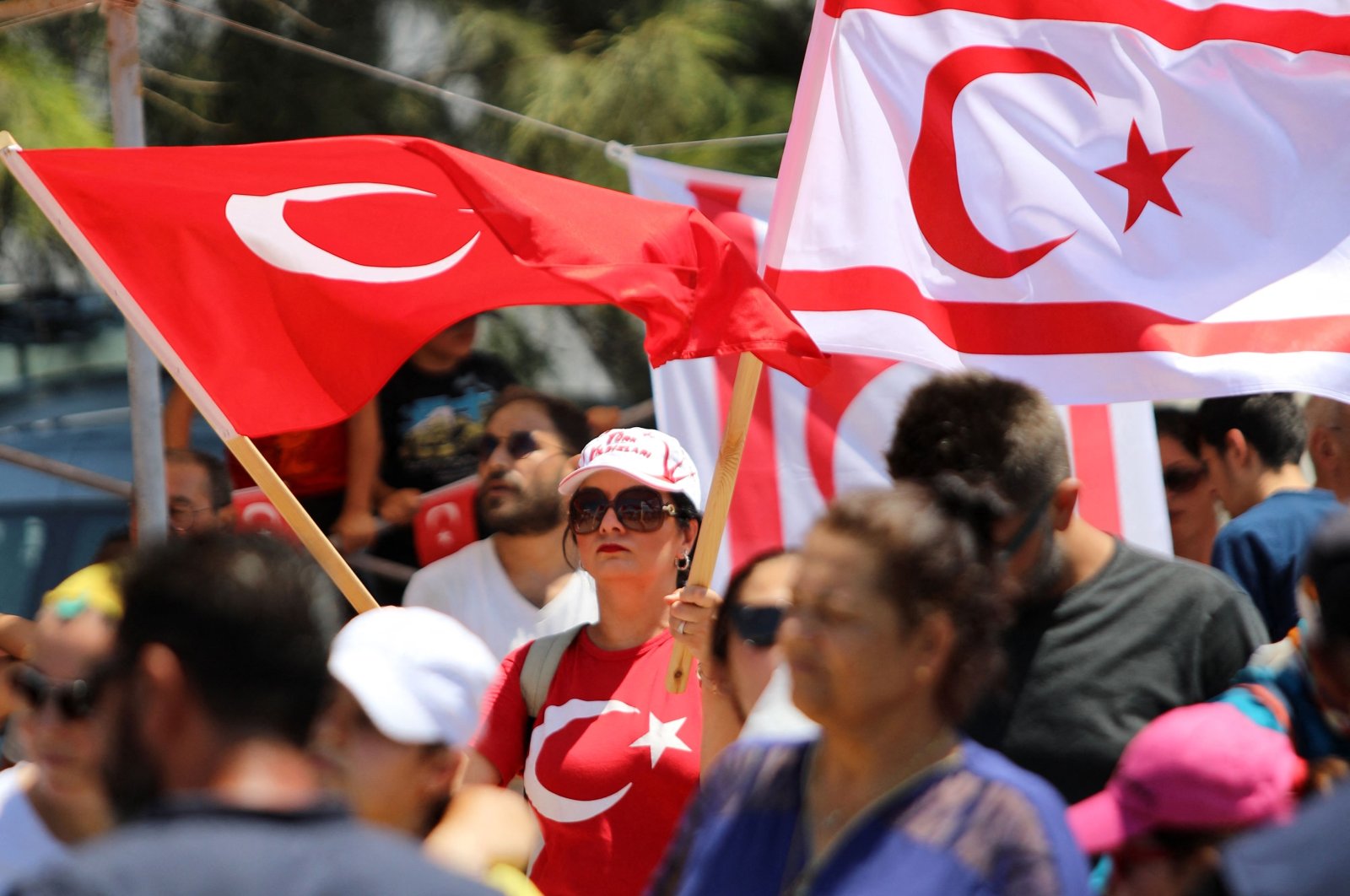 People wave Turkish Cypriot (R) and Turkish flags during a military parade on the anniversary of Türkiye's Peace Operation, Lefkoşa (Nicosia), Turkish Republic of Northern Cyprus, July 20, 2024. (AFP Photo)