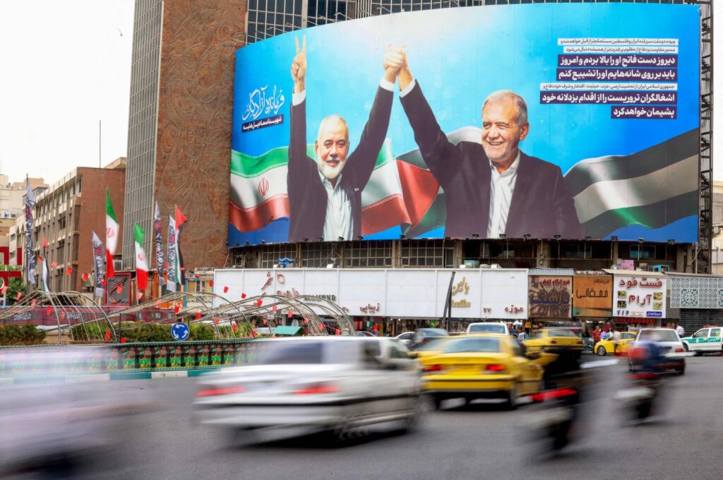 Vehicles drive past a huge billboard depicting Iranian President Masoud Pezeshkian (R) and slain Palestinian Hamas leader Ismail Haniyeh at Tehran's Valiasr square, Tehran, Iran, Aug. 12, 2024. (AFP Photo)