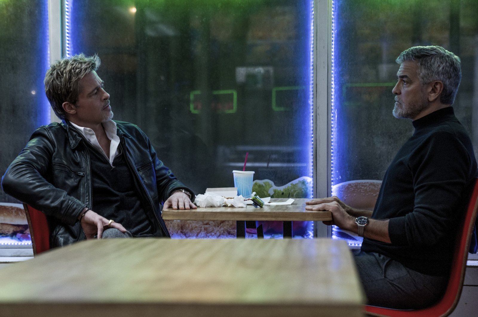This image released by Apple TV  shows Brad Pitt (L) and George Clooney in a scene from "Wolfs." (AP Photo)