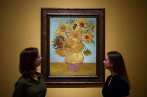 Visitors look at the painting  "Sunflowers" made by late Dutch artist Vincent Van Gogh in 1889, during a press preview for "Van Gogh: Poets and Lovers" exhibition at the National Gallery, London, U.K., Sept. 9, 2024. (AFP Photo)