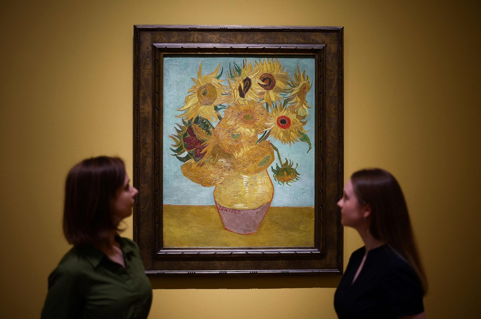 Visitors look at the painting  "Sunflowers" made by late Dutch artist Vincent Van Gogh in 1889, during a press preview for "Van Gogh: Poets and Lovers" exhibition at the National Gallery, London, U.K., Sept. 9, 2024. (AFP Photo)