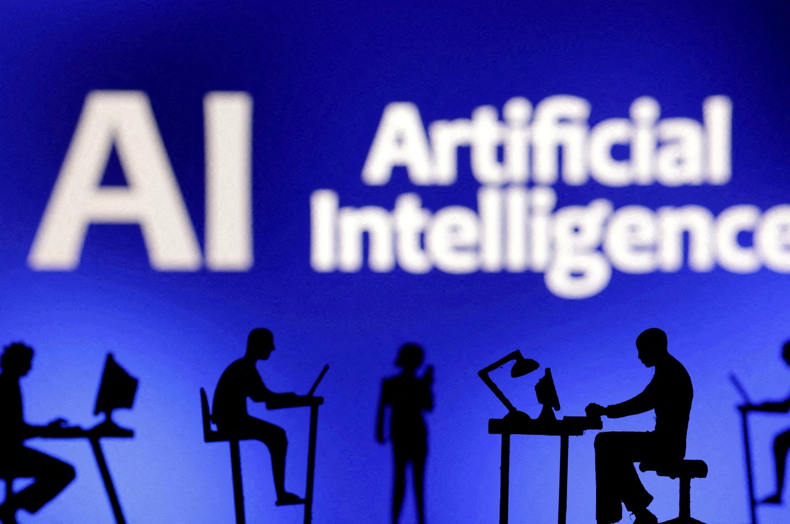 Figurines with computers and smartphones are seen in front of the words "Artificial Intelligence AI" in this illustration taken on Feb. 19, 2024. (Reuters Photo)