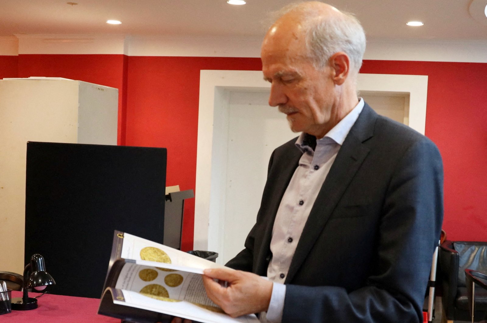 Michael Fornitz, professional numismatist and director of Stack's Bowers auction house, looks at the catalog for the first lot of coins from the coin collection of Danish butter magnate Lars Emil Bruun, Copenhagen, Denmark, Sept. 11, 2024. (Reuters Photo)