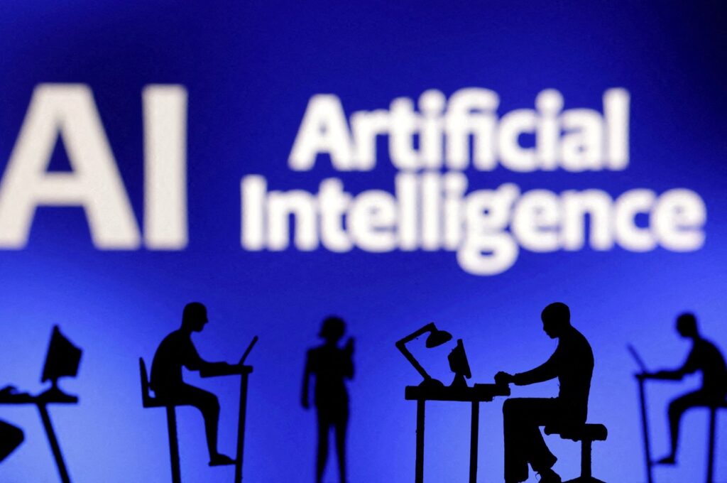 This illustration shows figurines with computers and smartphones in front of the words "AI Artificial Intelligence," Feb. 19, 2024. (Reuters Photo)