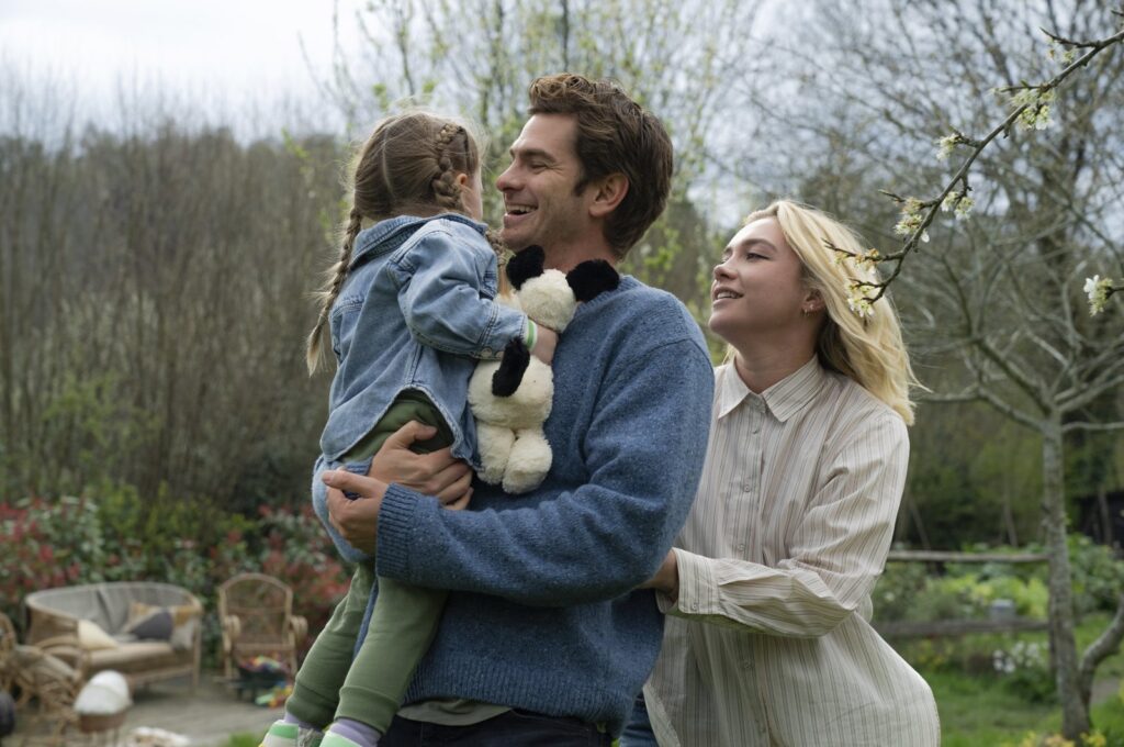This image released by A24 shows Andrew Garfield (C) and Florence Pugh (R) in a scene from "We Live In Time." (AP Photo)