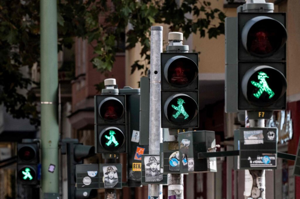 A row of pedestrian traffic signals featuring the former East German "Ampelmaennchen" ("little traffic signal man") show green at a pedestrian crossing, Berlin, Germany, Sept. 28, 2024. (AFP Photo)