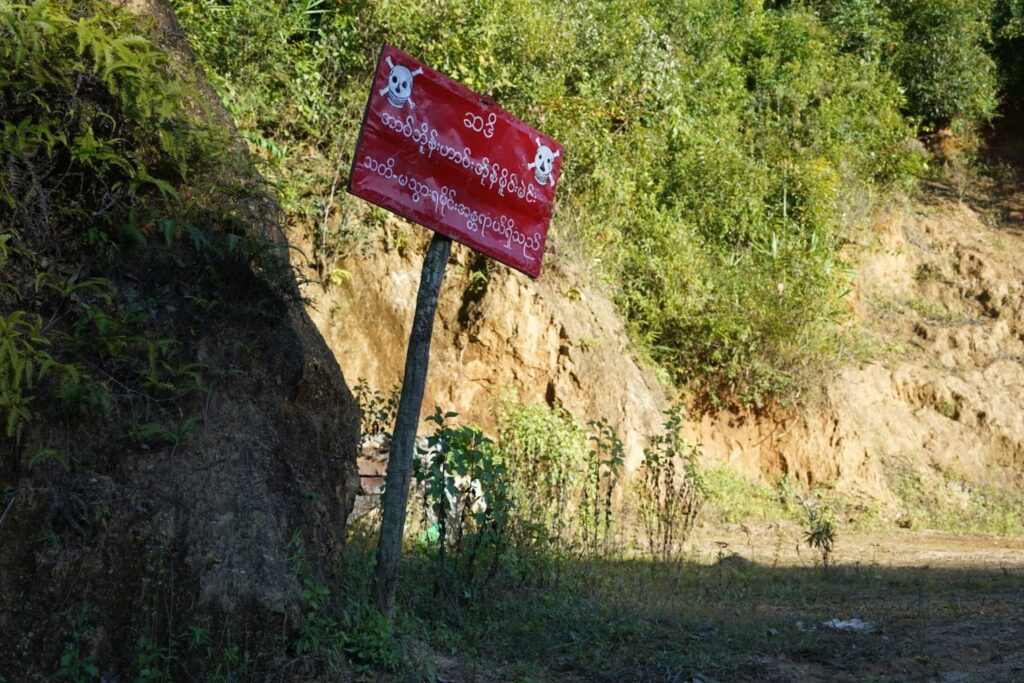 A sign reading "Warning, prohibited area - Land mines - Danger" alongside a road in Mantong town, northern Shan State, Myanmar, Nov. 17, 2024. (AFP Photo)