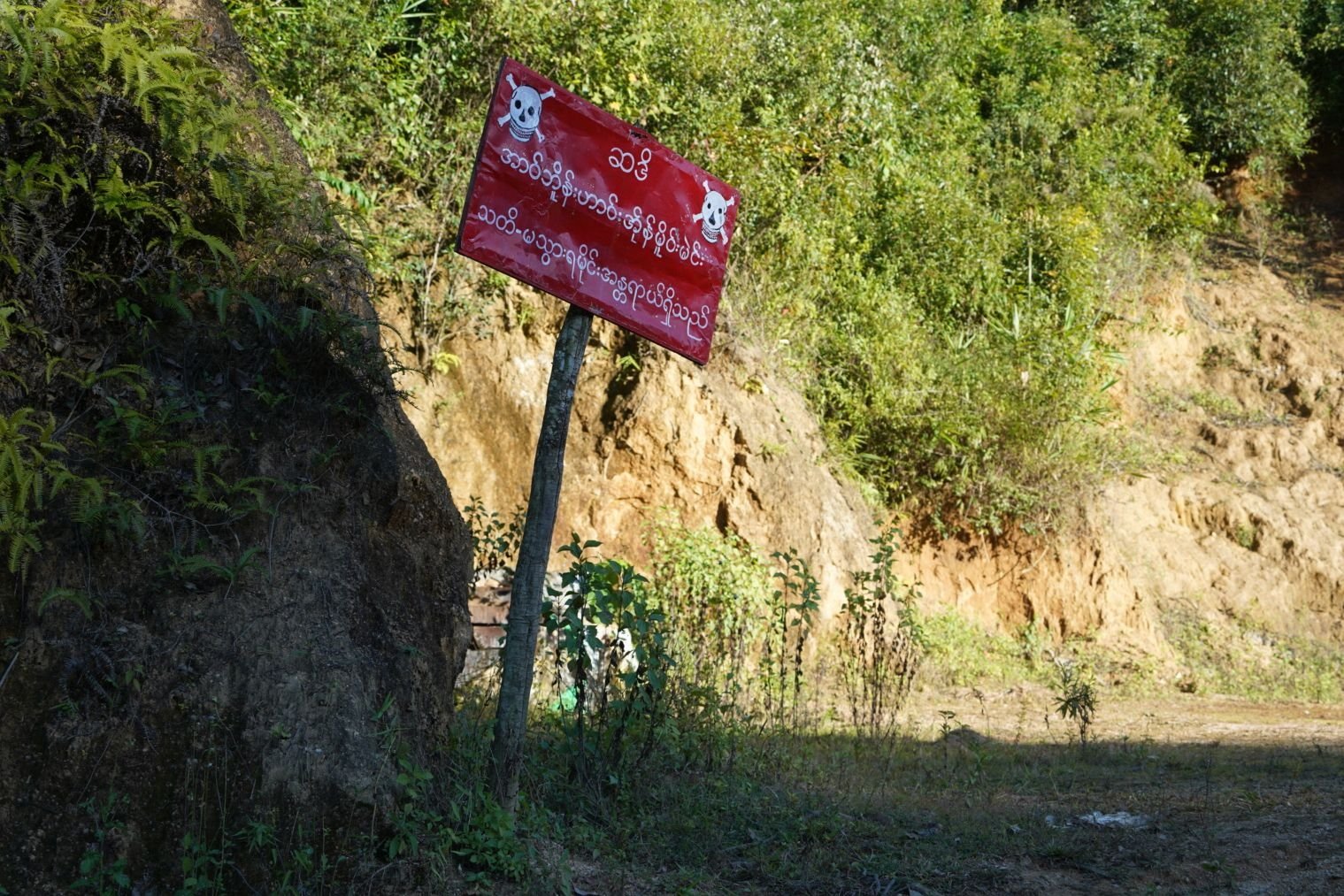 A sign reading "Warning, prohibited area - Land mines - Danger" alongside a road in Mantong town, northern Shan State, Myanmar, Nov. 17, 2024. (AFP Photo)