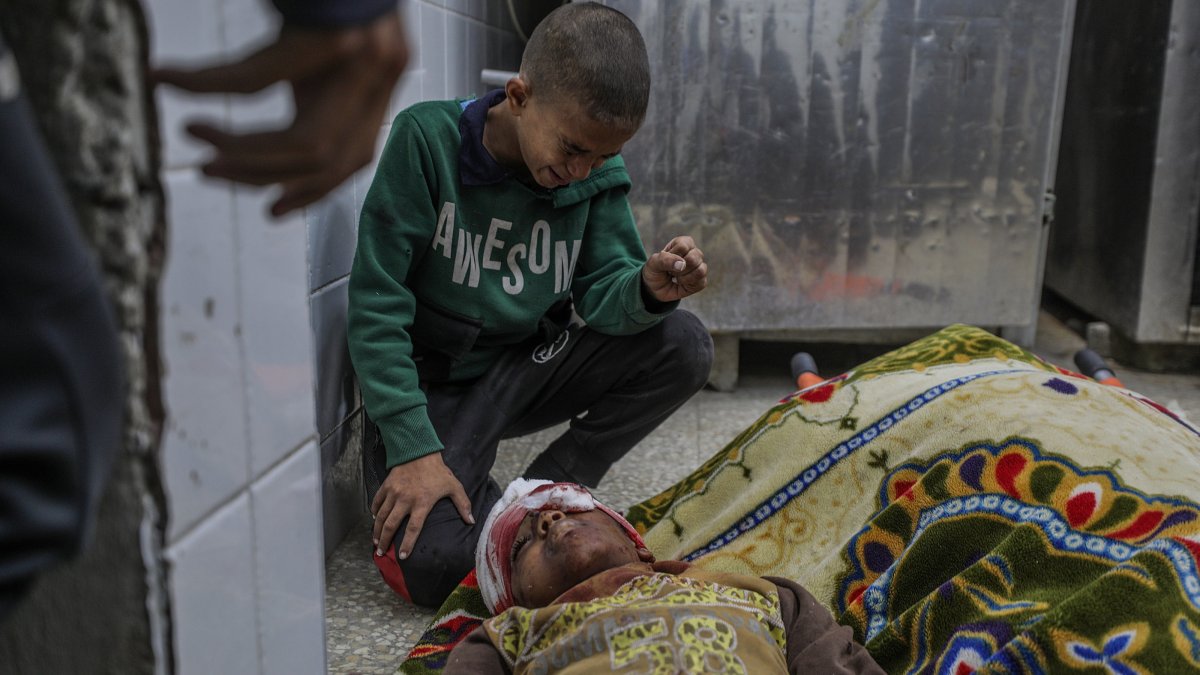 Ismail Faraj mourns over the body of his brother Shadi, 14, inside the morgue of al-Aqsa Hospital, following an Israeli attack on Bureije refugee camp, central Gaza Strip, Dec. 4, 2024. (EPA Photo)
