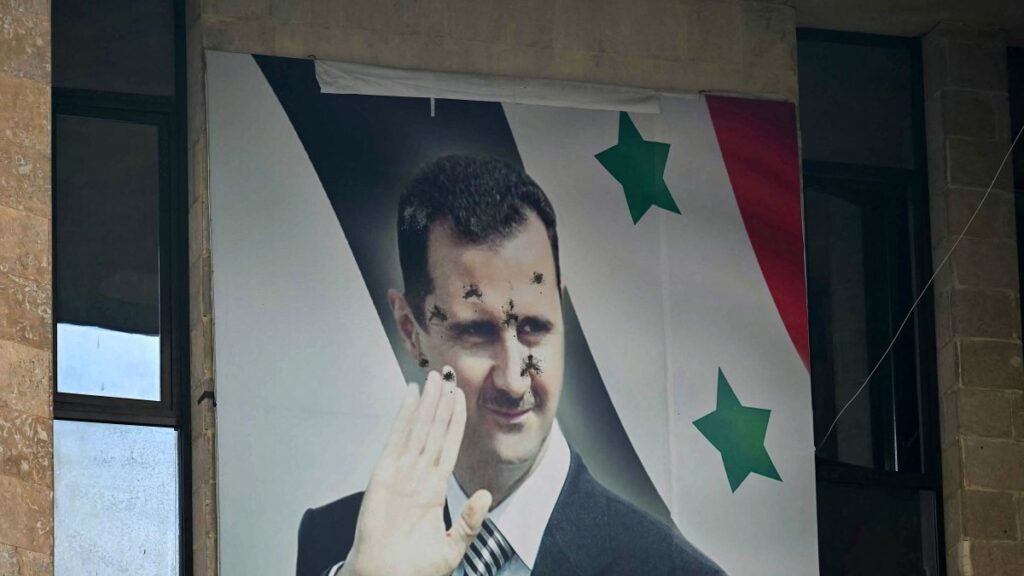 A bullet-riddled poster of toppled Syrian regime leader Bashar Assad hangs on a building, Aleppo, Syria, Dec. 12, 2024. (AFP Photo)