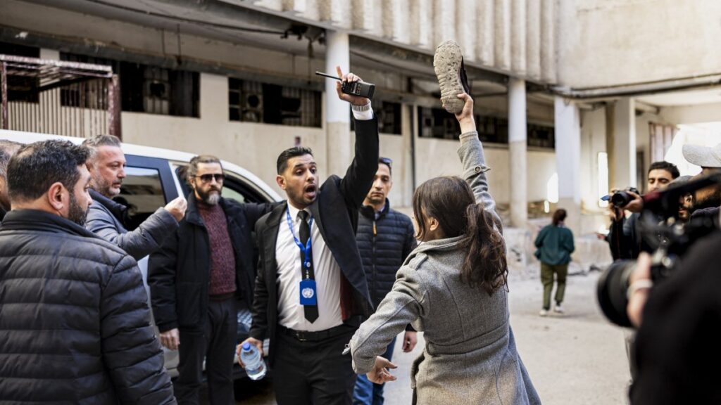 An angry woman looking for her missing brother and two of her cousins waves a shoe in front of the car of U.N.'s special envoy to Syrian during a visit at the Sadnaya prison in Damascus, Dec. 16, 2024. (AFP Photo)