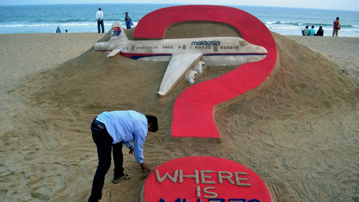 An Indian sand artist Sudarsan Pattnaik creates a sand sculpture of the missing Malaysia Airlines flight MH370 on Puri beach, Odisha state, India, March 7, 2015. (AFP Photo)