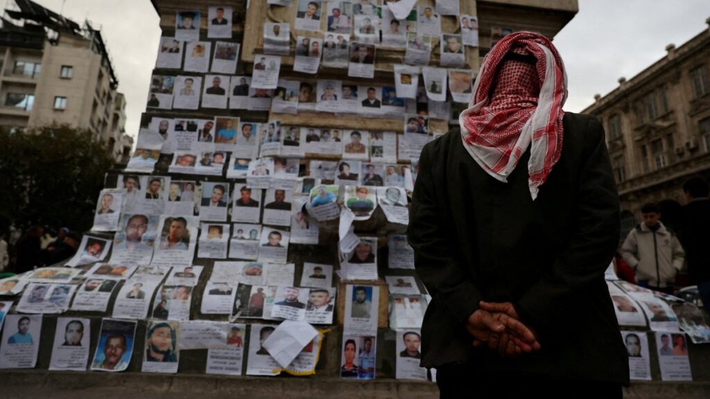 A man looks at the pictures of missing people, believed to be held in Sednaya prison, known as a "slaughterhouse" under Syria's Bashar Assad's rule, in Marjeh Square, Damascus, Syria Dec. 22, 2024. (Reuters Photo)