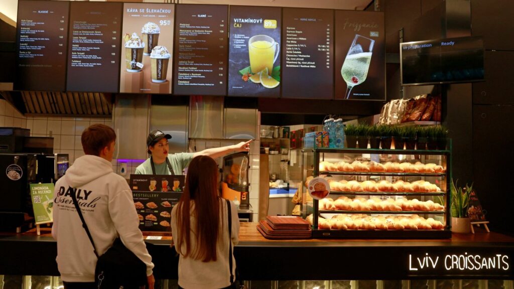 An employee takes a customer's order at Lviv Croissants bakery in a shopping mall, Prague, Czechia, Dec. 17, 2024. (Reuters Photo)