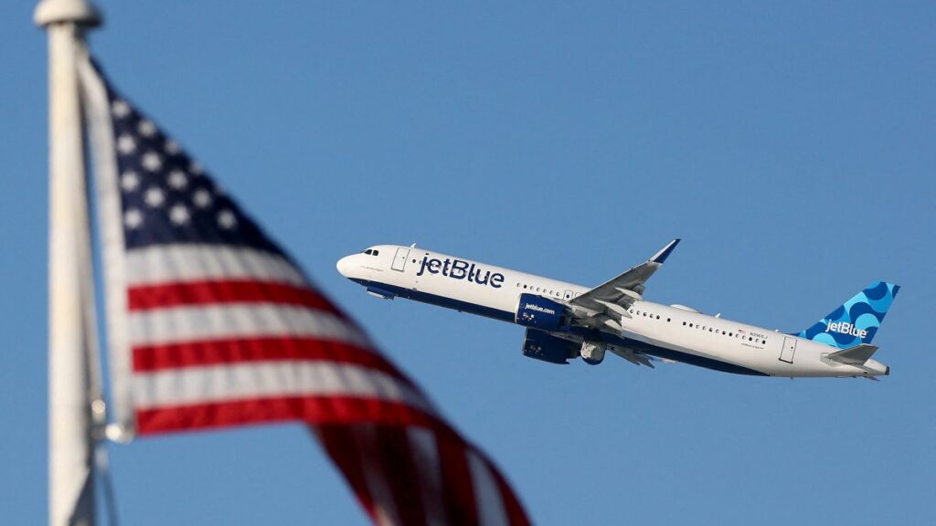 A JetBlue plane takes off from Los Angeles International Airport (LAX) beyond an American flag in Los Angeles, California Jan. 3, 2025. (AFP File Photo)