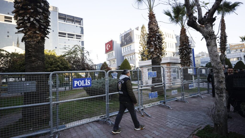 A police officer patrols along barricades set up outside the Akdeniz Municipality building following Mayor Hoşyar Sarıyıldız's detention in Mersin, Türkiye, Dec. 10, 2024. (AA Photo)