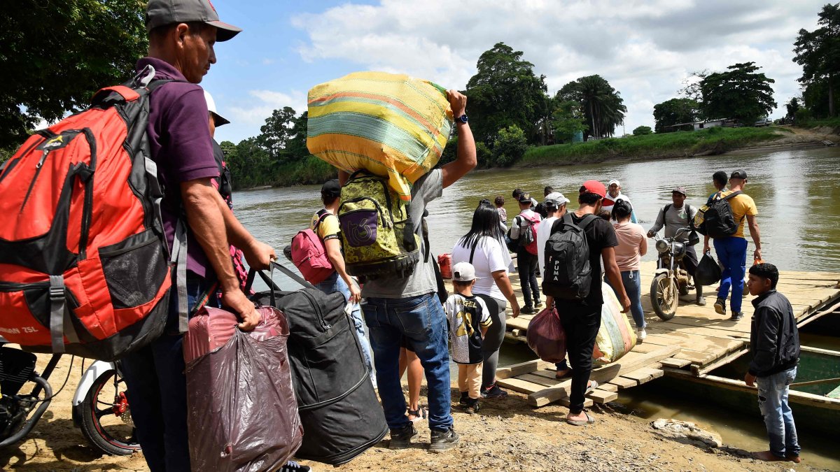 Displaced people from recent clashes between armed groups board canoes to cross the Tarra River, which divides Colombia and Venezuela, Norte de Santander department, Tibu, Colombia, Jan. 19, 2025. (AFP Photo)