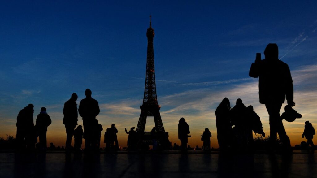 Tourists are silhouetted against the sunset as they take pictures on a cold day in Trocadero Square near the Eiffel Tower, Paris, France, Jan. 14, 2025. (Reuters Photo)