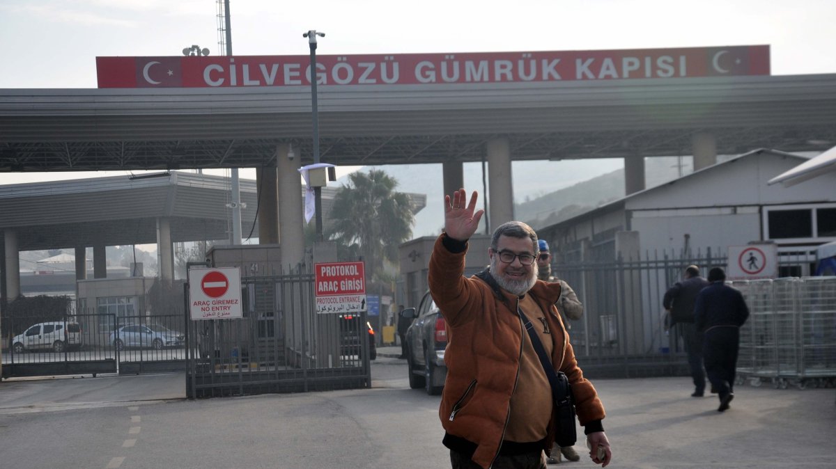 A Syrian man waves at a photojournalist as he prepares to cross the border to Syria, in southeastern Hatay province, Türkiye, Jan. 13, 2025. (DHA Photo)