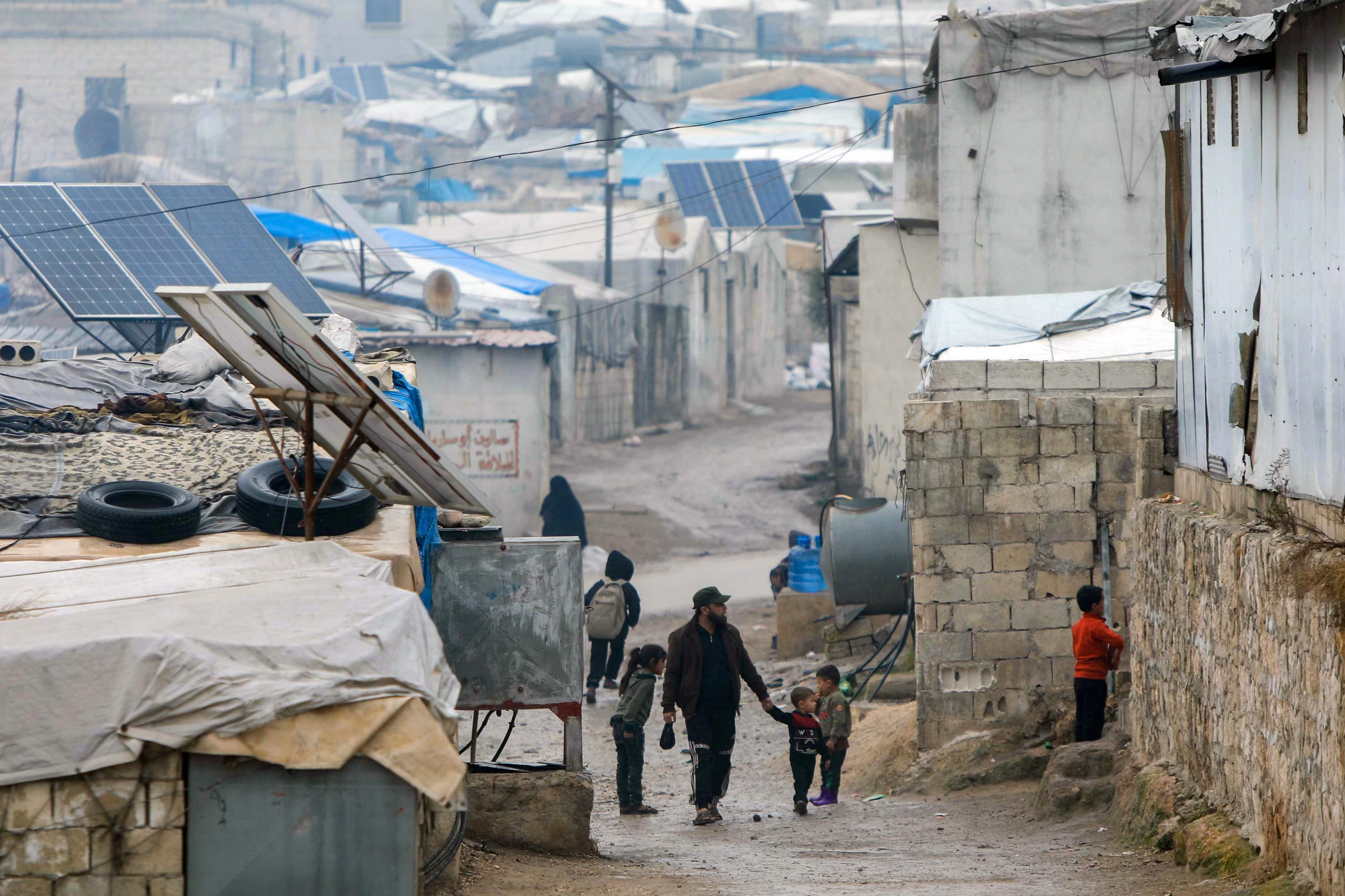 368179 A man and children walk in the camp of Atme for displaced people, on the outskirts of Idlib in northwestern Syria, Feb. 5, 2025. (AFP Photo)