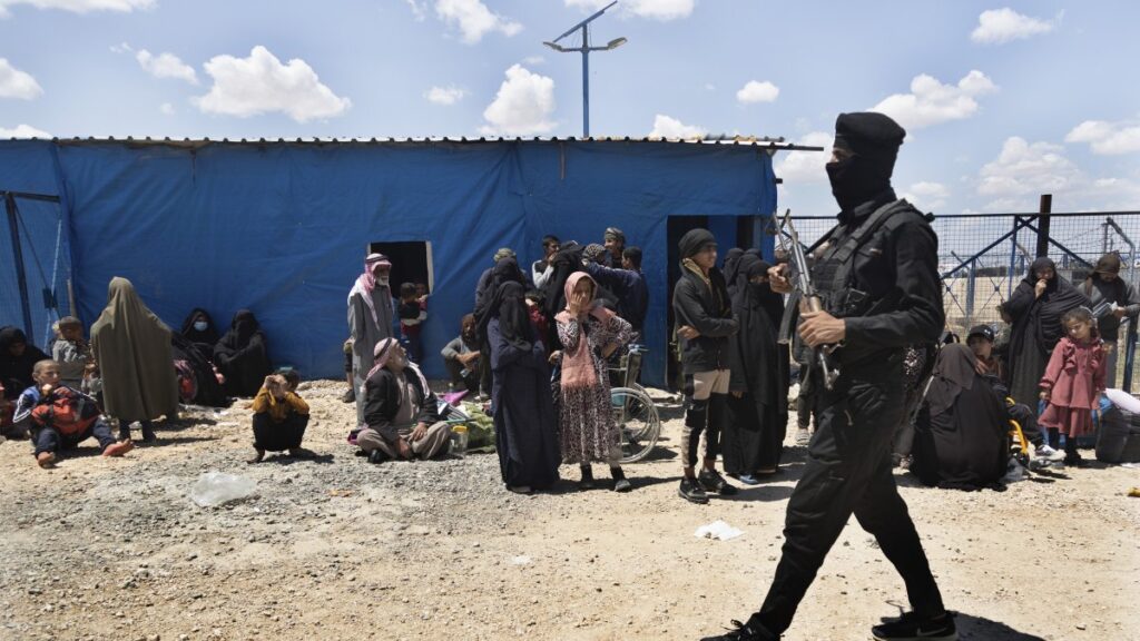 A U.S.-backed PKK/YPG terrorist passes in front of family members of suspected Daesh terrorists who are waiting to be transferred from the al-Hol camp, Hassakeh province, Syria, May 8, 2024. (AP Photo)