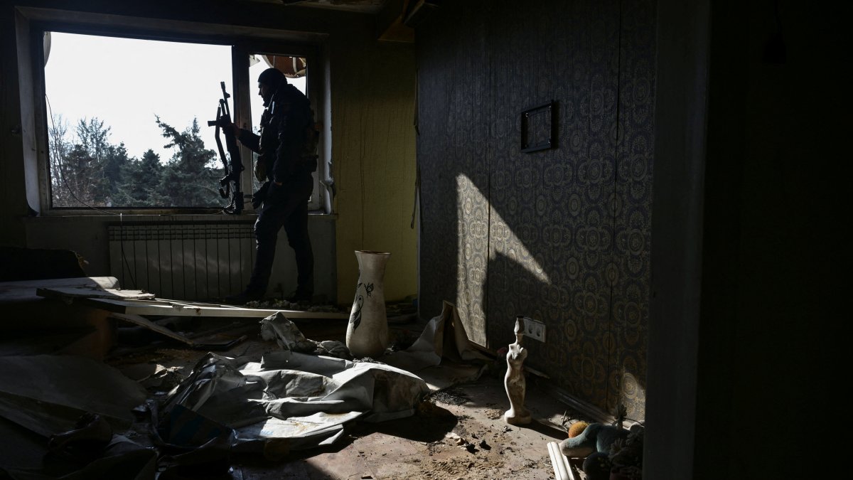 A police officer observes an area for enemy drones from an apartment building damaged by Russian military strikes, in Orikhiv, Zaporizhzhia region, Ukraine, Feb. 12, 2025. (Reuters Photo)