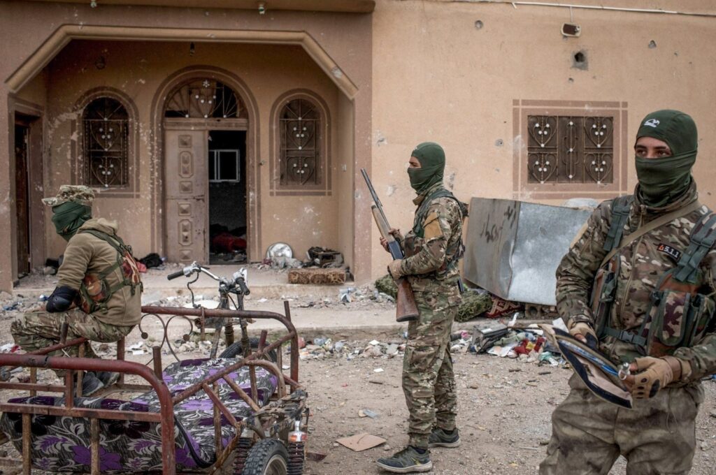 YPG/PKK terrorists are seen in front of a building, Baghouz, Syria, March 24, 2019. (Getty Images Photo)