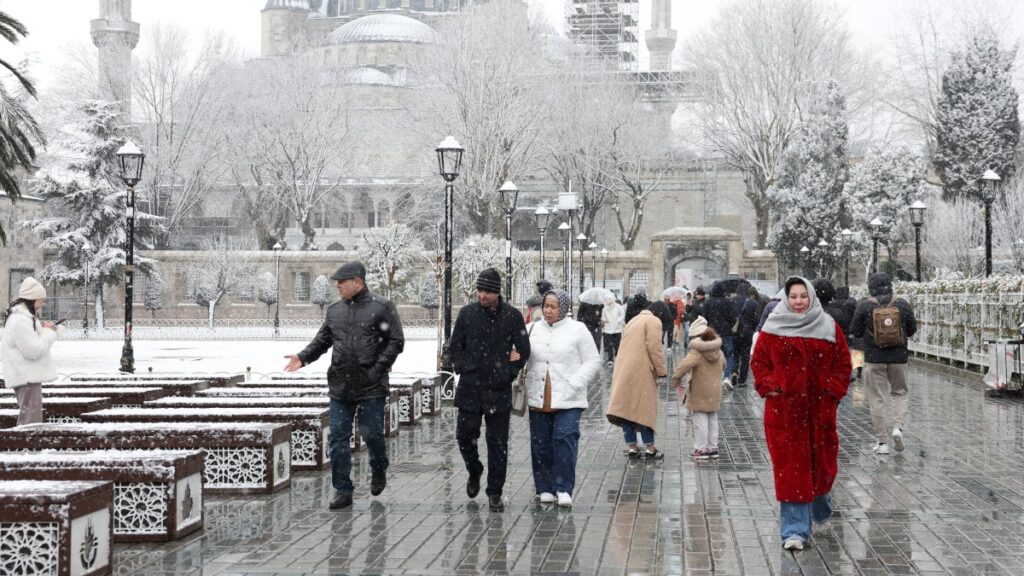 People, with the Ottoman-era Sultan Ahmed Mosque, known as the Blue Mosque, in the background, walk during a snowfall, Istanbul, Türkiye, Feb. 20, 2025. (Reuters Photo)