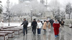 People, with the Ottoman-era Sultan Ahmed Mosque, known as the Blue Mosque, in the background, walk during a snowfall, Istanbul, Türkiye, Feb. 20, 2025. (Reuters Photo)