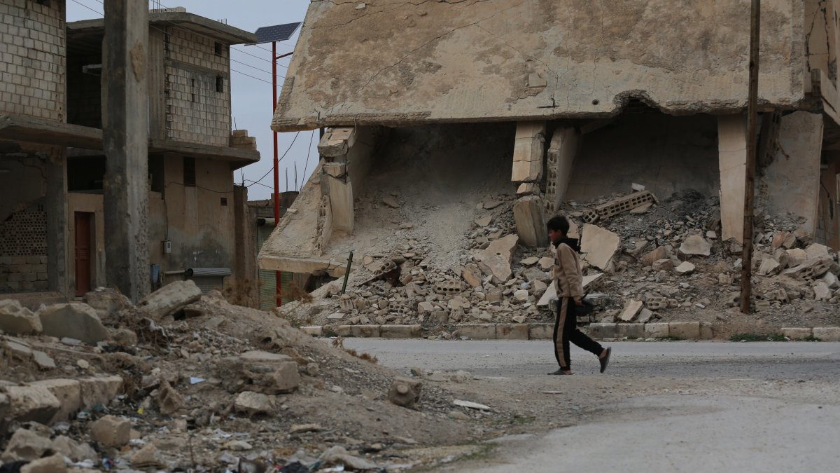 A boy walks along a street with destroyed buildings in the town of al-Hafta, east of Manbij, Syria, Feb. 25, 2025. (AA Photo)