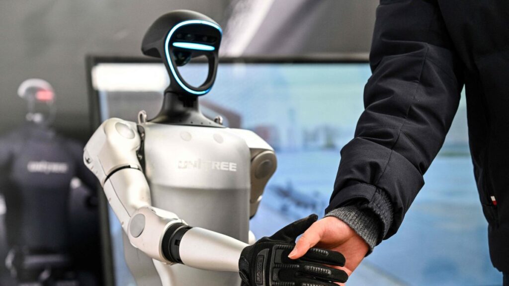 A man shakes hands with a humanoid robot from Unitree Robotics during the Global Developer Conference, organised by the Shanghai AI Industry Association, Shanghai, China, Feb. 21, 2025. (AFP Photo)